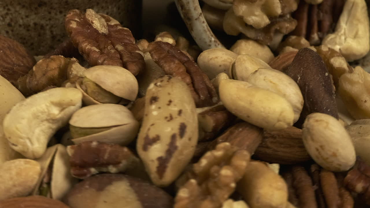 Full frame macro closeup: Healthy mixed roasted nuts revolve, detail