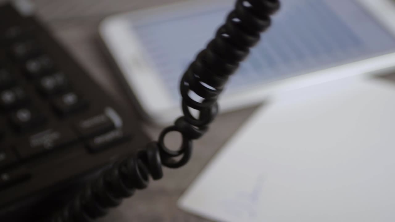 Office phone coil hangs as conversation takes place