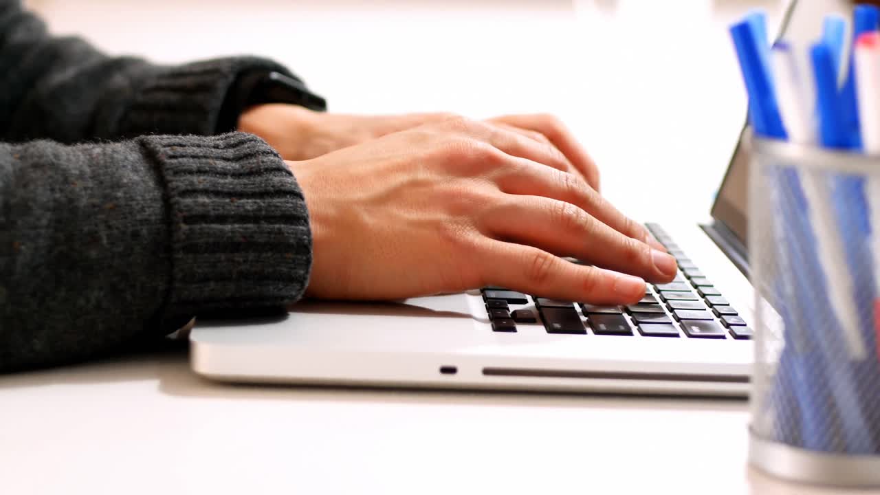 Mid section of male executive using laptop