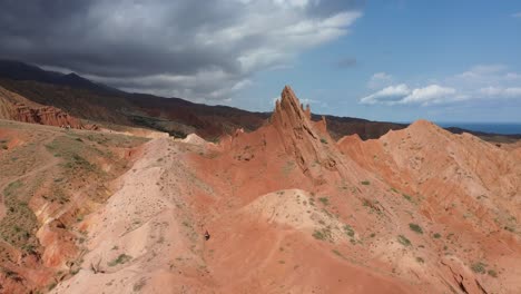 aerial view showcasing the dramatic rock formations of fairytale canyon skazka in kyrgyzstan while someone hikes up the base