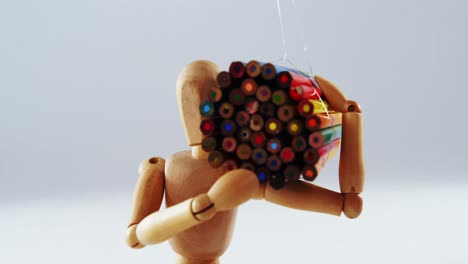 figurine carrying bunch of colored pencil