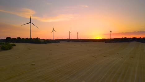 aerial view windmills silhouettes wind turbines in field backlit with warm sun light during sunset or sunrise