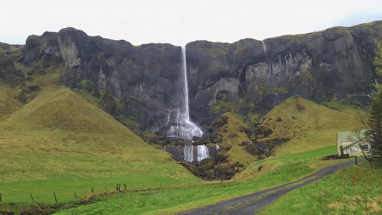 paisaje de islandia, cascadas, acantilados volcánicos y pastizales verdes en días de lluvia