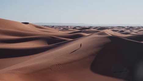 Nómada-Solitario-Caminando-Sobre-Dunas-De-Arena-Del-Interminable-Desierto-Del-Sahara,-Vista-De-Mano