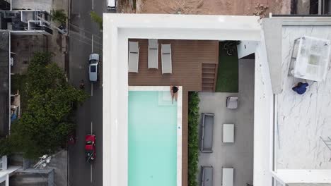 Vista-De-Drones-Que-Muestra-A-Una-Chica-En-Bikini-Disfrutando-De-Una-Hermosa-Piscina-Vacía