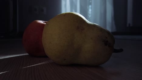 Ein-Apfel-Und-Eine-Birne-Im-Sonnenuntergang,-Mit-Einer-Kreisförmigen-Dolly-Bewegung