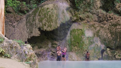 group of people standing under tumalog falls