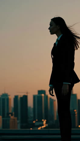 businesswoman silhouette on rooftop at sunset