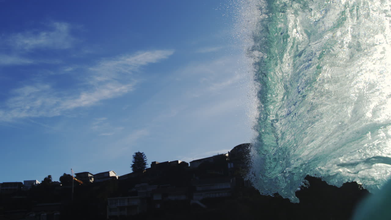 Slow motion ocean wave glows in sunlight, fluid and abstract