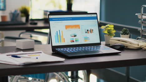 wheelchair in inclusive office and laptop showing marketing report data