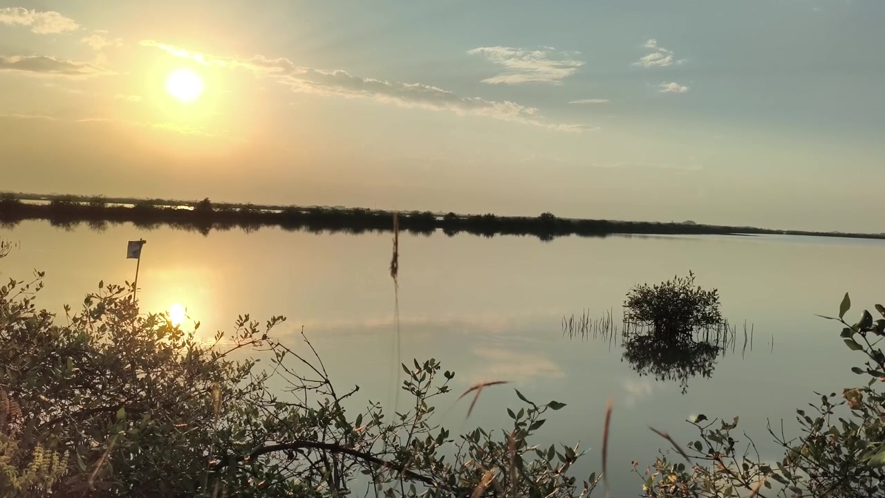 Tramonto sereno su un lago calmo con acqua riflettente.