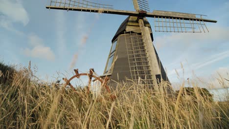 old windmill revealed through grass while tilting up