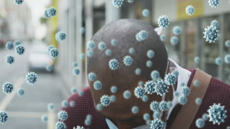 animation of covid 19 cells over man wearing face mask