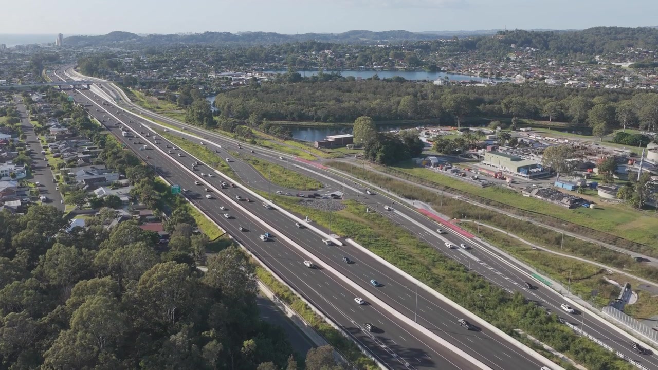 Autopista del Pacífico (M1) con tráfico en movimiento cerca del arroyo Tallebudgera en Palm Beach, Queensland, Australia. Toma aérea amplia