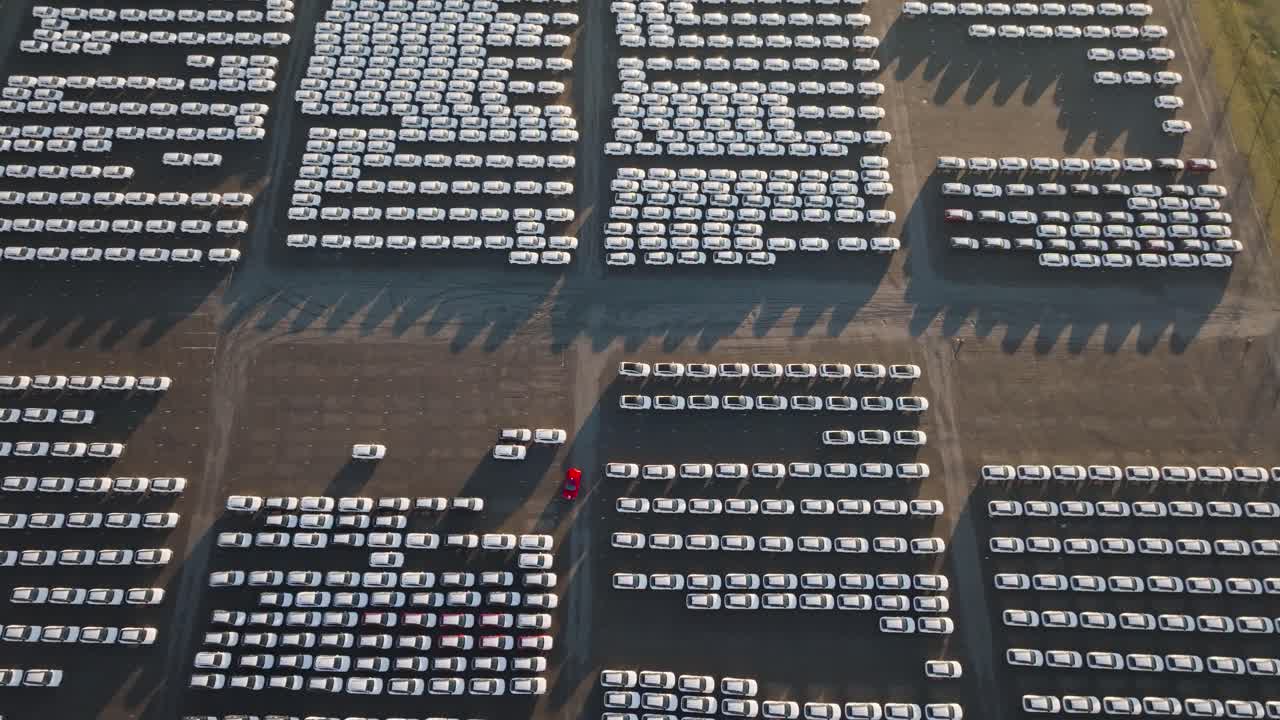 Aerial perspective over filled parking lot with mass production vehicles