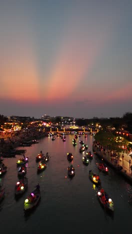 beautiful sunset aerial over lantern boats full of tourists at the beautiful hoi an lantern celebration, vertical video