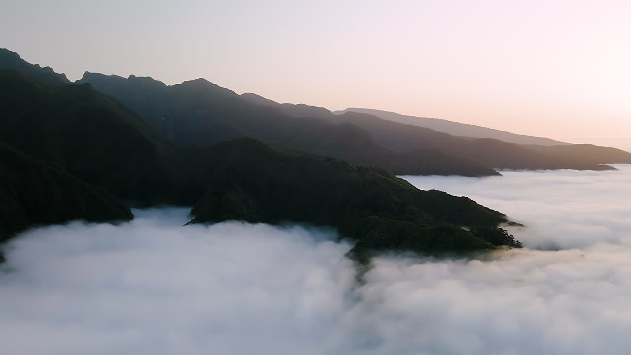 montañas madeira altas sobre el cielo con mar de nubes al atardecer - toma aérea