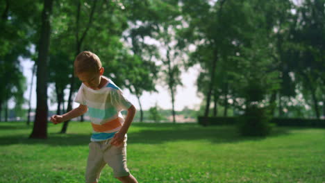 little boy training before soccer match. kid warming up alone in sunny park.