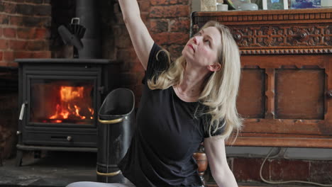 woman doing yoga indoors by fireplace