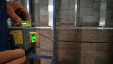 the builder measures the repair lines using a green laser level