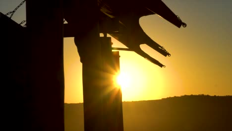 Slow-moving-silhouetted-shot-of-a-marquee-tent-with-the-sun-rising-in-the-background