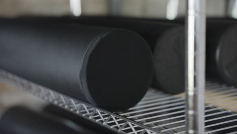 An-image-showcasing-foam-rollers-neatly-arranged-on-a-gym-shelf-in-a-close-up-view