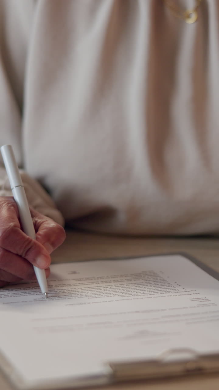 mujer firmando un documento en un escritorio