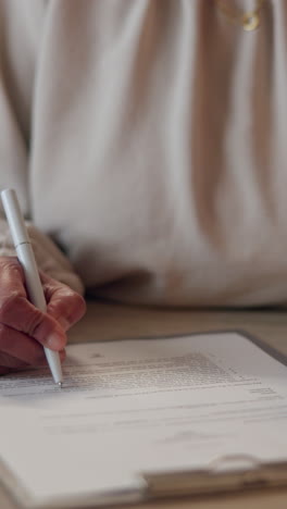 mujer firmando un documento en un escritorio