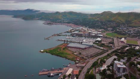 Port-Moresby-Harbour-Marina-car-traffic-Papua-New-Guinea-aerial-drone-morning-cloudy-foggy-sunrise-PNG-Crown-Hotel-Plaza-Hilton-Ela-Beach-Walter-Bay-Coral-Sea-coastline-capital-city-backwards-pan-up