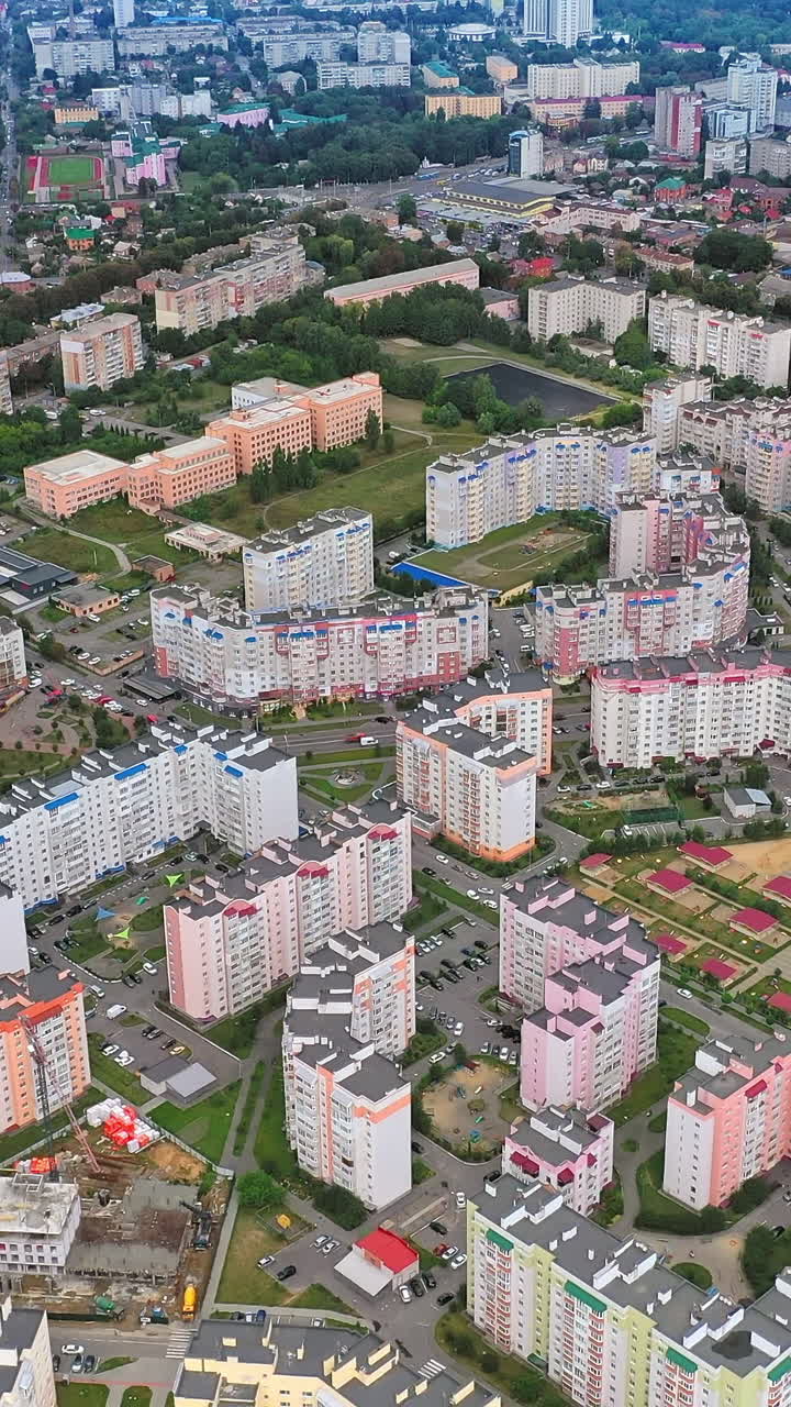 Contemporary district with multi-storey buildings. New apartment buildings of modern design. Residential landmarks in a new district of a city. Aerial view. Vertical video