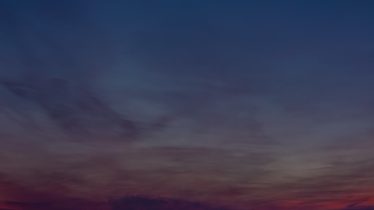 lapso de tiempo de nubes coloreadas por el sol poniente moviéndose sobre el horizonte