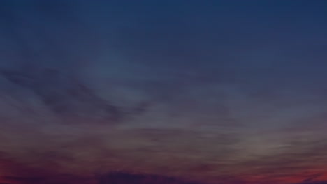 timelapse of clouds colored by the setting sun moving over the horizon