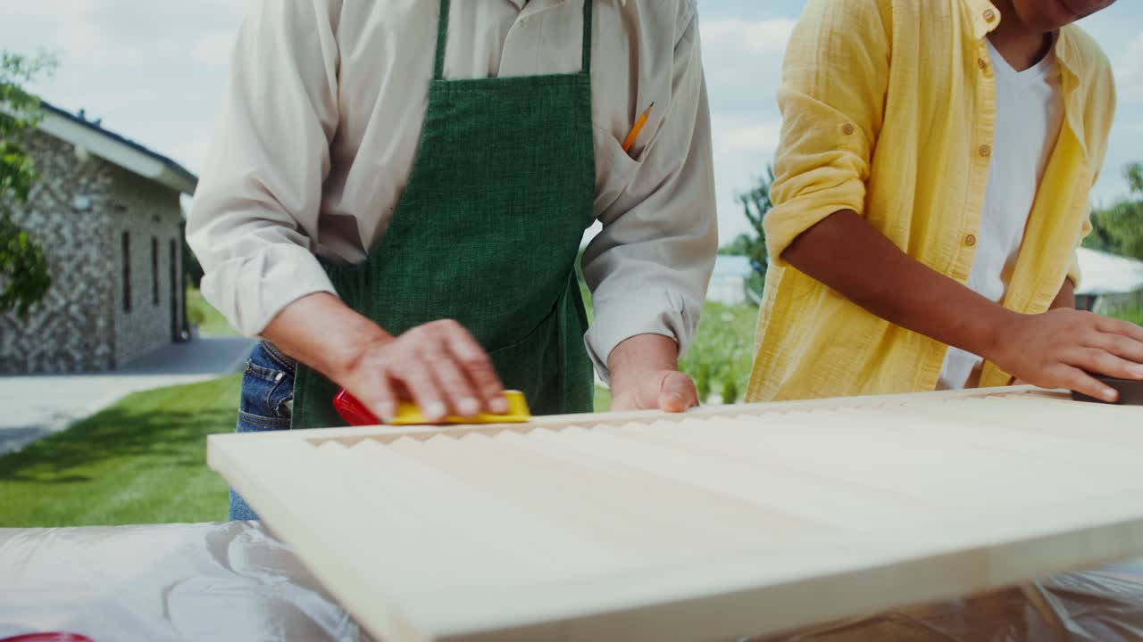 할아버지 와 손자 가 함께 목재 프로젝트 를 하고 있다