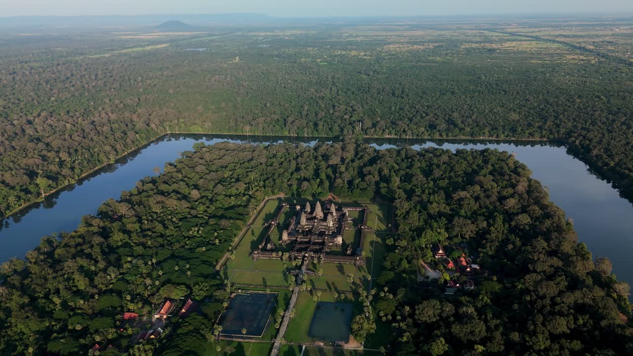 An aerial orbit right showcases Angkor Wat surrounded by forest and the moat, revealing the temple’s layout and its landscape setting