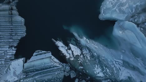 Desde-Arriba,-Témpanos-De-Hielo-De-Formas-Asombrosas-Flotando-En-Agua-Verde-Azulado,-Sur-De-Islandia