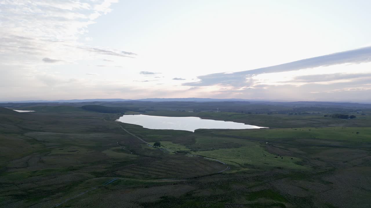 공중 접근 호수와 혼자 회전 풍력 터빈은 안개 아침에
