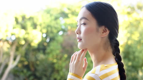 thinking deeply, woman with braided hair looking into distance outdoors