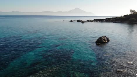 Yoga-Matutino-En-Una-Roca-Con-Vistas-Al-Famoso-Monte-Athos-En-Grecia