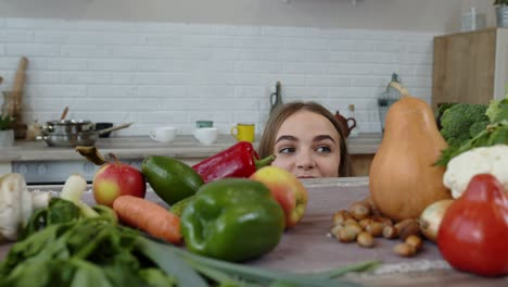 Chica-Asomando-Por-Debajo-De-La-Mesa-Y-Robando-Manzana-Fresca-Y-Comiéndola.-Pérdida-De-Peso,-Concepto-De-Dieta