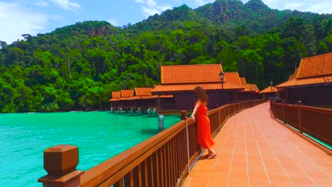 a woman relaxed on a stilt house of a luxury hotel looks at the sea in the island of langkawi