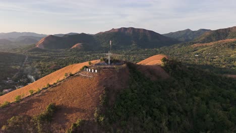 aerial perspective at sunset of the cross and coron sign at the top of the hill at coron town, philippines