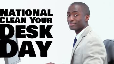 Animation-of-national-clean-your-desk-day-text-over-african-american-businessman-using-computer