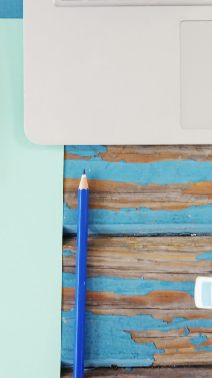 una taza de té, papel, lápiz, auriculares y portátil