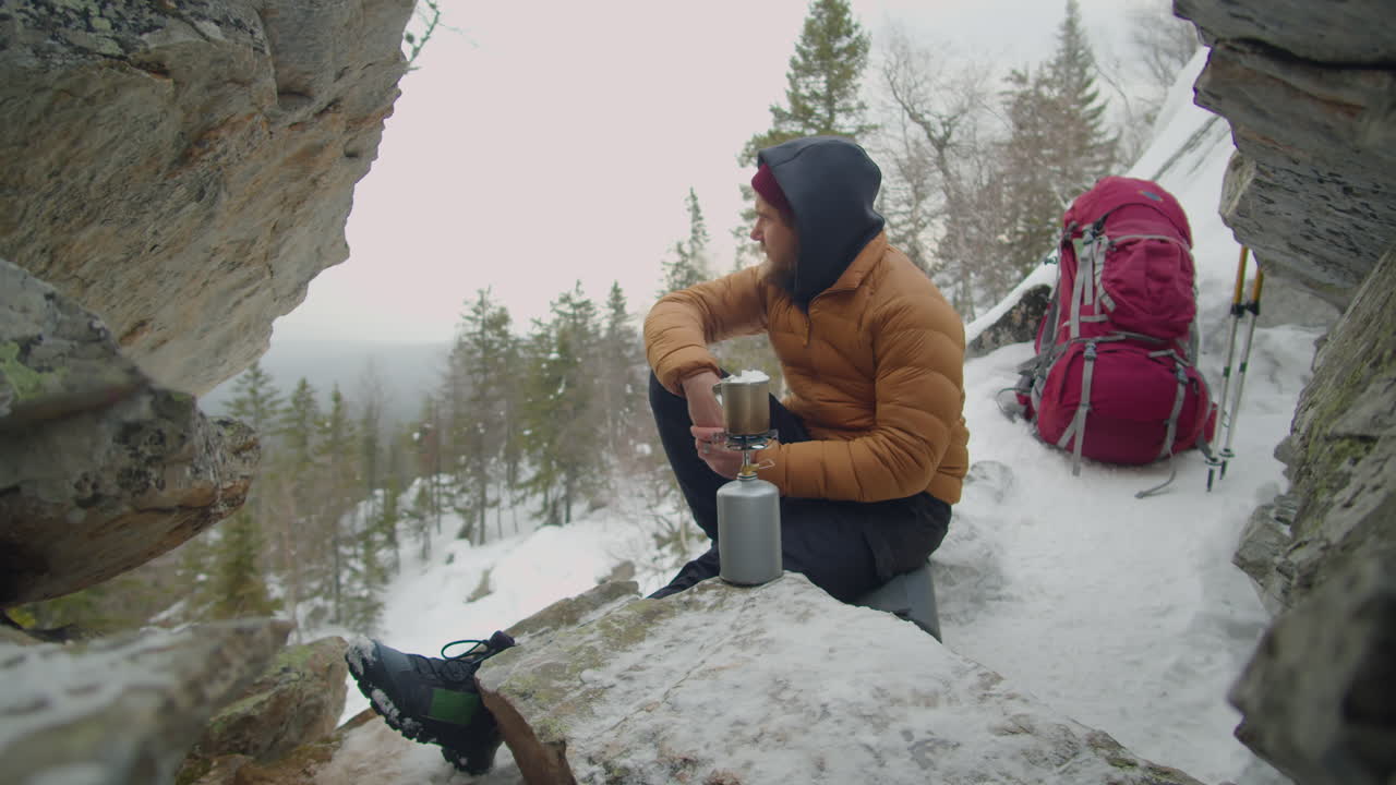 Man Using Portable Gas Stove while Camping in Mountains