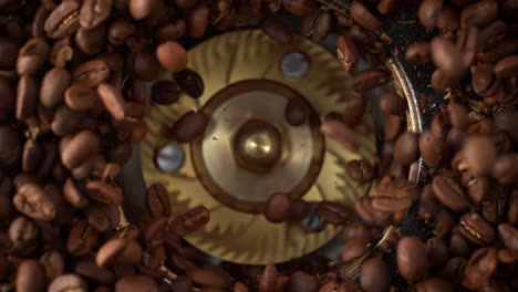 molienda de granos de café tostados girando en el molinillo de burr en cámara lenta y macro - vista superior