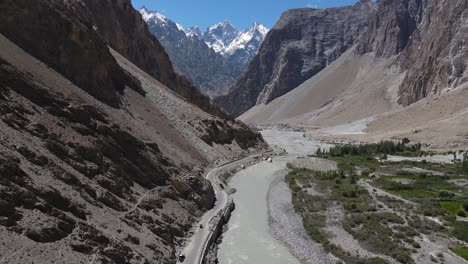 Vista-Aérea-De-La-Carretera-Y-El-Río-Glacial-En-Las-Tierras-Altas-De-Pakistán,-Valle-De-Hunza-En-Un-Día-Soleado-De-Verano,-Disparo-De-Drones