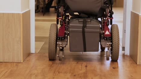 un hombre en silla de ruedas conduce por el pasillo. una persona con discapacidad se mueve por el hospital.