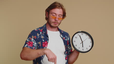 bearded young man showing time on clock watch, ok, thumb up, approve, pointing finger at camera