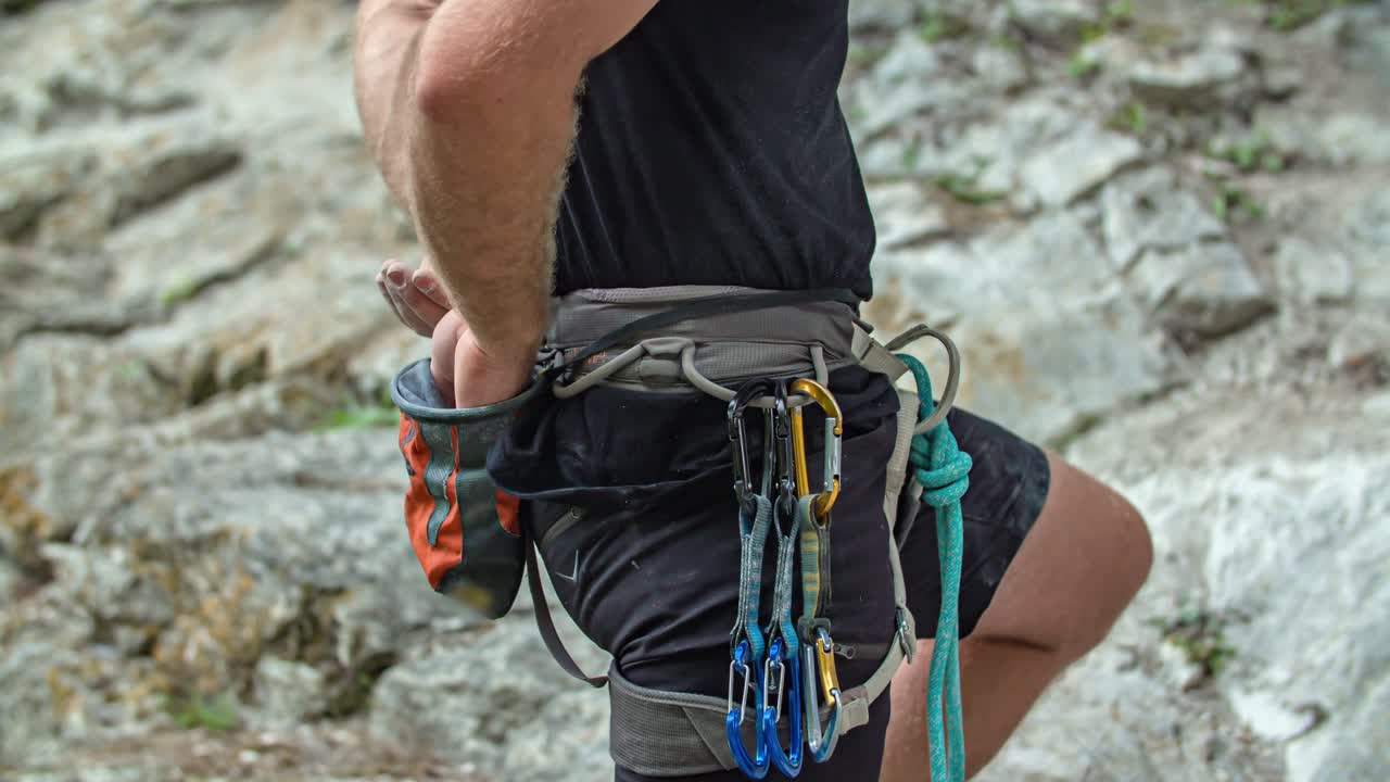 Climber use chalk bag while climbing mountain Burjakove Peci, Slovenia