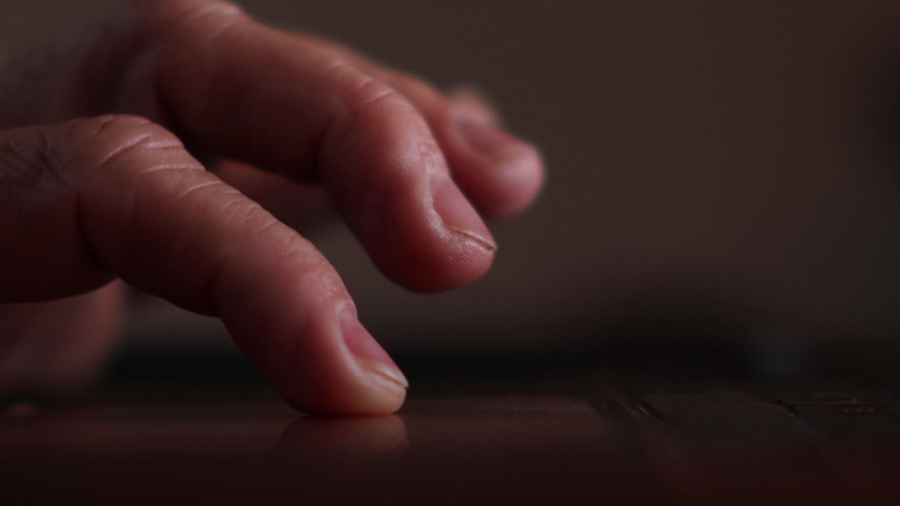 화면에 백라이트가 켜진 노트북의 트랙 패드를 스크롤하고 탭하는 사람의 손가락 클로즈업